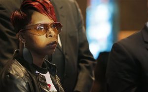 FILE - In this March 5, 2015, file photo, Lesley McSpadden, mother of Michael Brown Jr., listens to the family attorney during a news conference in Dellwood, Mo. Lawyers for the parents of Brown, the unarmed, black 18-year-old who was fatally shot by a white police officer in a St. Louis suburb, announced Wednesday, April 22, 2015, that they planned to file a civil lawsuit the following day against the city of Ferguson. (AP Photo/Charles Rex Arbogast, File)