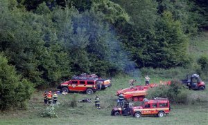 A rescue vehicle pulls the debris of an airplane that collided with another near the village of Cerveny Kamen, Slovakia, Thursday, Aug. 20, 2015. Two planes carrying dozens of parachutists collided in midair Thursday over western Slovakia, killing several people, officials said. More than thirty others on board survived by jumping out with their parachutes. (AP Photo/Petr David Josek)