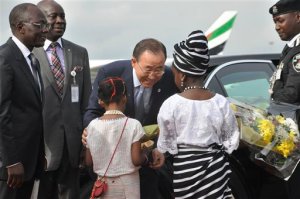 U.N Secretary General Ban Ki-Moon, center. receives flowers from a girl upon his arrival at Nnamdi Azikiwe International airport in Abuja, Nigeria Sunday, Aug. 23, 2015. U.N. Secretary General Ban Ki-moon arrived in Nigeria Sunday to mark the Boko Haram bombing of his organization's headquarters and focus new attention on 219 schoolgirls held by the extremist group. (AP Photo/Gbemiga Olamikan)
