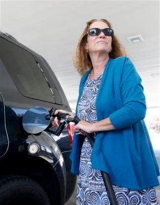 Babette Davis fills the gas tank of her vehicle at a gas station in Sacramento, Calif., Thursday, Sept. 24, 2015. The California Air Resources Board is expected to decide, on Friday, to restore rules requiring a 10 precent cut in carbon emissions on fuels sold in the state, by 2020, despite oil industry objections that it could drive up gas prices. (AP Photo/Rich Pedroncelli)