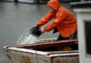 Pound net fisherman Brian Wilson bails water from one of his boats docked on Saturday, Sept.3, 2016 as Tropical Storm Hermine approaches Virginia Beach, Va.  The National Hurricane Center says Tropical Storm Hermine could bring 4 to 7 inches of rain to southeastern Virginia and the Atlantic coastal portion of Maryland as well as 1 to 4 inches of rain over southern Delaware, southern and eastern New Jersey and Long Island through Monday morning.  (Stephen M. Katz/The Virginian-Pilot via AP)