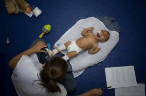 In this Sept. 30, 2016 photo, 1-year-old Jose Wesley Campos, who was born with microcephaly, cries during his physical therapy session at the AACD rehabilitation center in Recife, Brazil. Jose is like a newborn. He is slow to follow objects with his crossed eyes. His head is unsteady when he tries to hold it up, and he weighs less than 13 pounds, far below the 22 pounds that is average for a baby his age. (AP Photo/Felipe Dana)