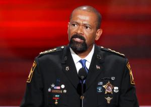 FILE - In this July 18, 2016 file photo, Milwaukee County Sheriff David Clarke speaks during the opening day of the Republican National Convention in Cleveland. Milwaukee resident Dan Black says Clarke had deputies question him after a flight because he shook his head at the lawman, who has gained national prominence for supporting Donald Trump. Black says in a complaint submitted to the sheriff's website, he shook his head because Clarke was wearing Dallas Cowboys clothes on Sunday, Jan. 15, 2017, when they played the Green Bay Packers. (AP Photo/J. Scott Applewhite, File)