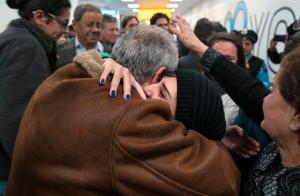 FILE - In a Monday, Feb. 6, 2017 file photo, family members who have just arrived from Syria embrace and are greeted by family who live in the United States upon their arrival at John F. Kennedy International Airport in New York. Organizers in cities across the U.S. are telling immigrants to miss class, miss work and not shop on Thursday, Feb. 16, 2017,  as a way to show the country how important they are to America's economy and way of life. "A Day Without Immigrants" actions are planned in cities including Philadelphia, Washington, Boston and Austin, Texas. (AP Photo/Craig Ruttle)